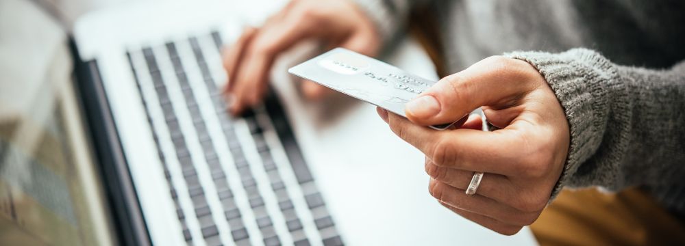 woman paying online holding credit card