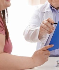 Woman discussing gastric sleeve versus gastric bypass with doctor holding a clipboard