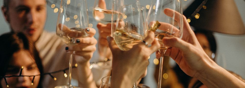 multiple people raising glasses of wine